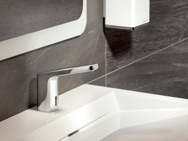 Touchless, chrome-plated mixer tap on a white washbasin